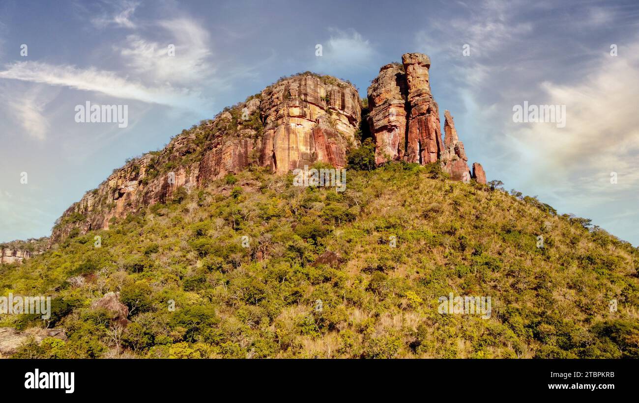 Eine atemberaubende, sonnenverwöhnte Landschaft mit felsigem Gelände und üppigem grünem Sträucher Stockfoto