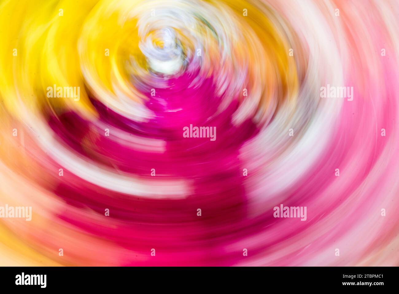 Eine lebendige Nahaufnahme einer mehrfarbigen Spirale, die in der Luft wirbelt und einen auffälligen Bewegungsunschärfeeffekt erzeugt Stockfoto