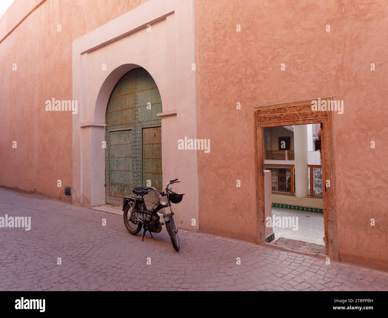 Oldtimer-Motorrad neben einem Kupfertor in der Medina (Historic Wall Centre) Marrakesch aka Marrakesch, Marokko, 08. Dezember 2023 Stockfoto