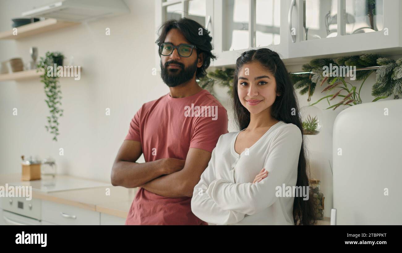 Verschiedene verheiratete Paare multirassische Hausbesitzer Ehepartner, die Arme in der Hausküche überkreuzt posieren lächelnde Eltern arabischer Mann Mann Mann Guy indische Frau Stockfoto