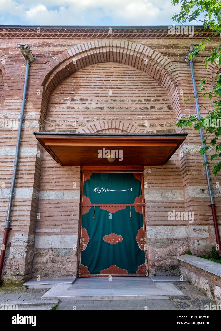 Seiteneingang der Zeyrek-Moschee, Moschee im Stil der mittelbyzantinischen Architektur aus dem 14. Jahrhundert, Istanbul, Türkei. Der Text an der Tür sagt: Im Namen Gottes, der gnädigste, der barmherzigste Stockfoto