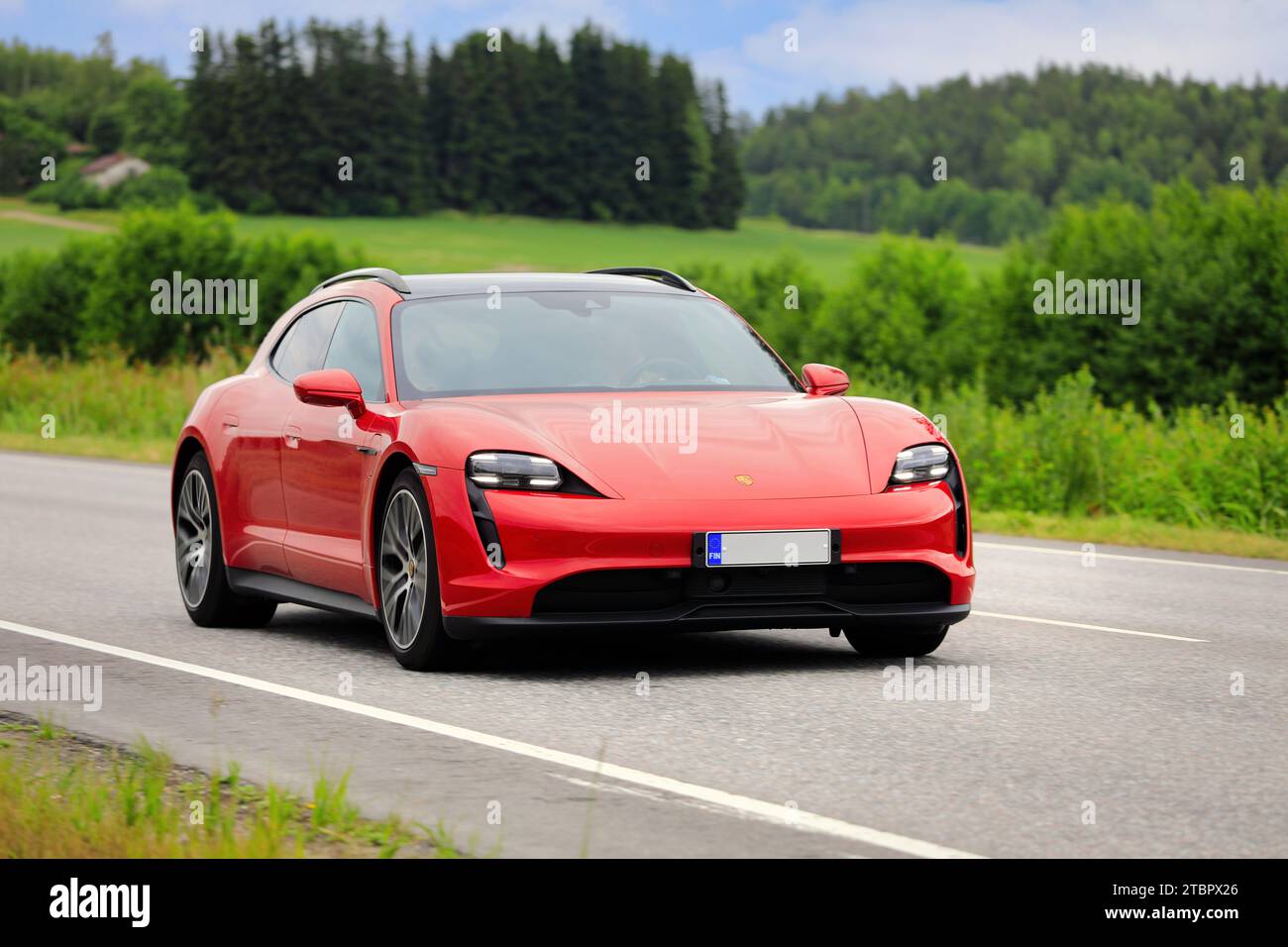 Wunderschönes rotes Porsche Taycan Sport Turismo Jahr 2022 Elektroauto auf der Landstraße an einem sonnigen Sommertag. Salo, Finnland. Juli 2023. Stockfoto