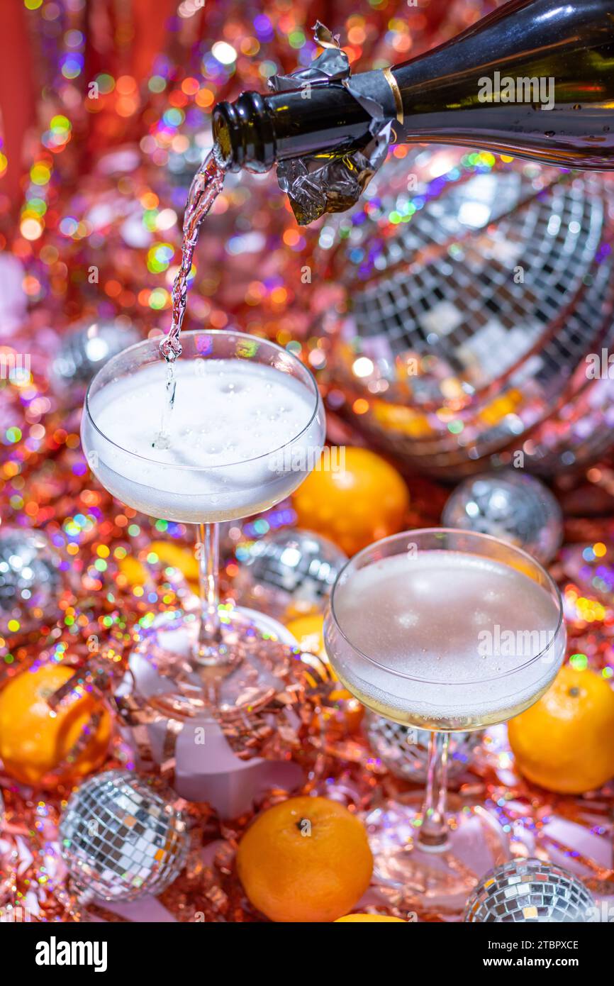 Festlicher Sekt für eine lebhafte Disco-Party, Silvester in Pink, Orange und Rot. Stockfoto