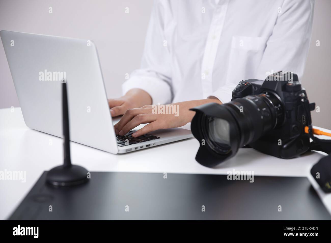 Fotografin, Bloggerin, die mit ihrer Kamera aufgenommene Fotos mit einem Laptop überprüft Stockfoto