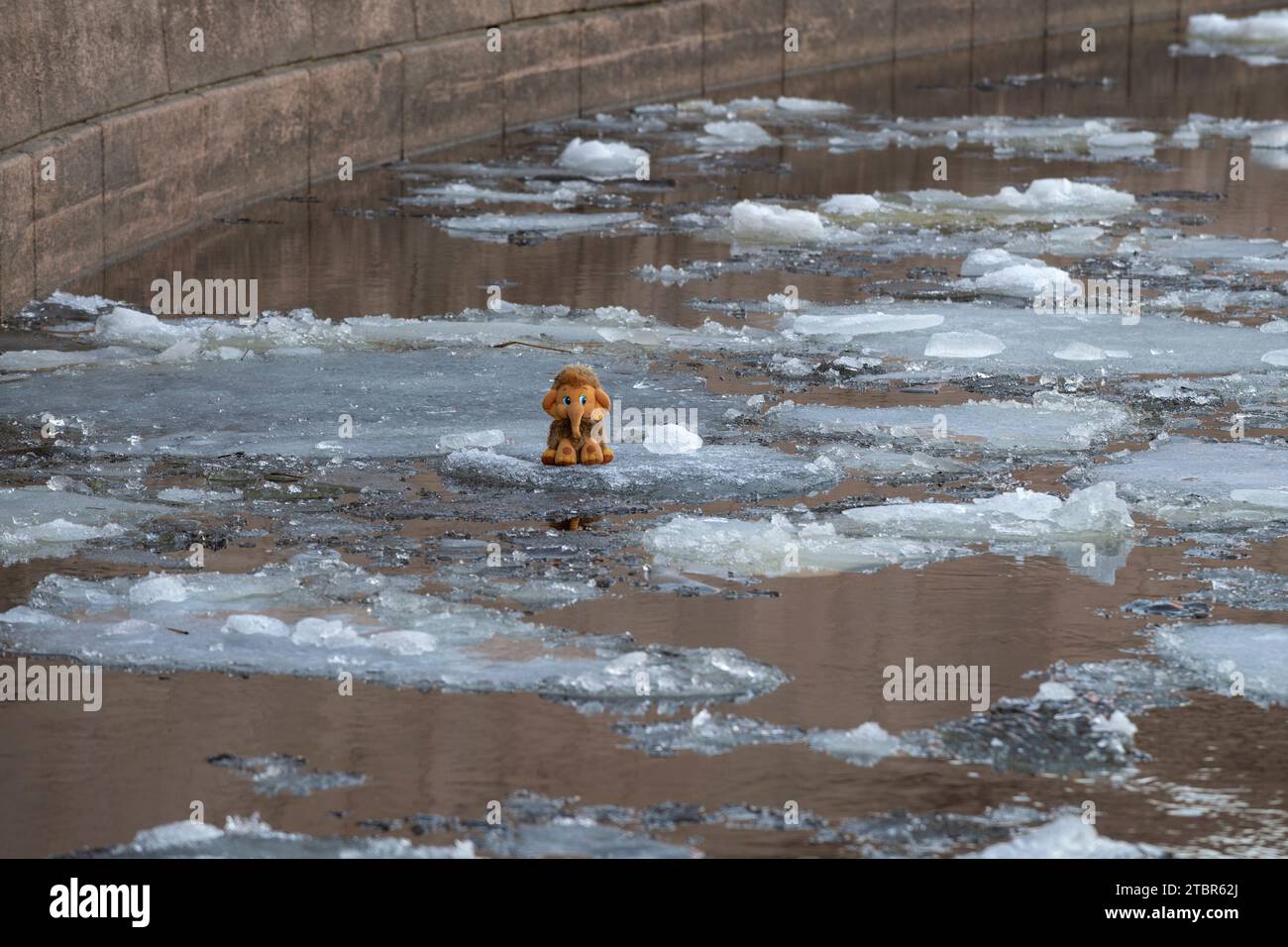 ST. PETERSBURG, RUSSLAND - 12. APRIL 2023: Ein Kuschelspielzeug Baby Mammut schwimmt auf einer schmelzenden Eisscholle Stockfoto