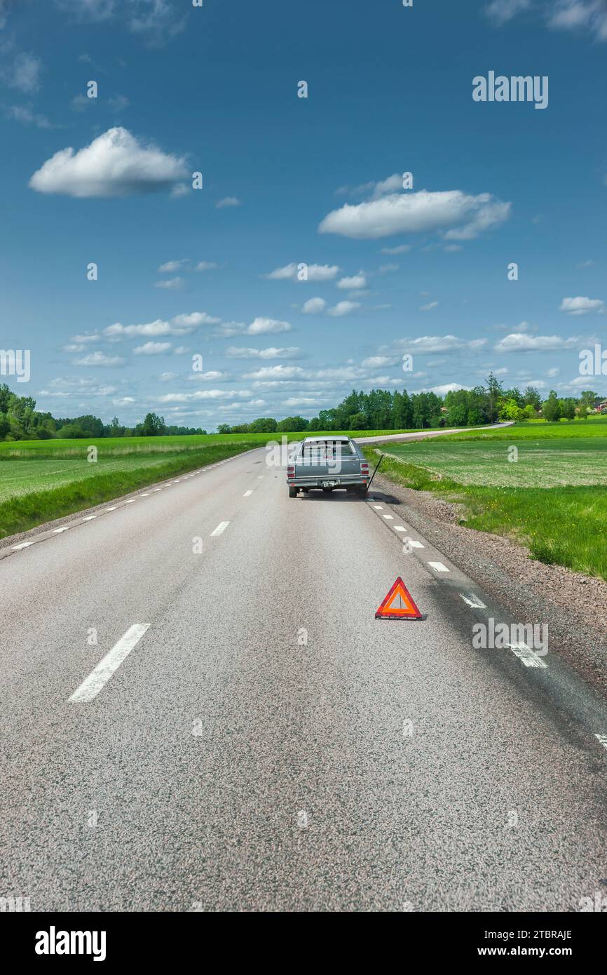 Panne auf einer Landstraße mit Warndreieck auf der harten Schulter Stockfoto