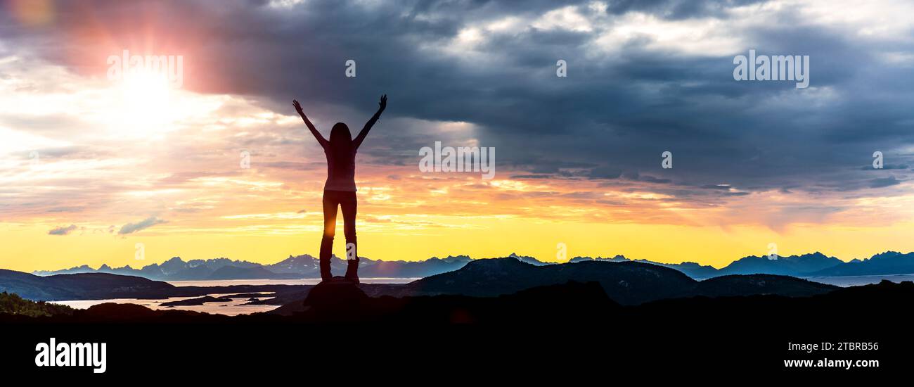 Der Lofoten-Archipel bei Sonnenuntergang, Silhouette einer Frau mit ausgestreckten Armen Stockfoto