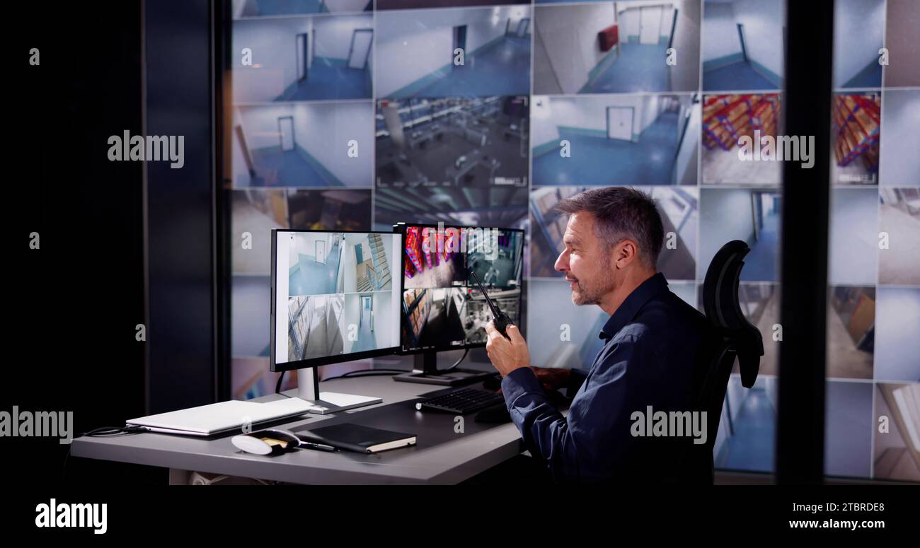 Der Sicherheitsbeamte überwacht das CCTV-System im Raum Stockfoto
