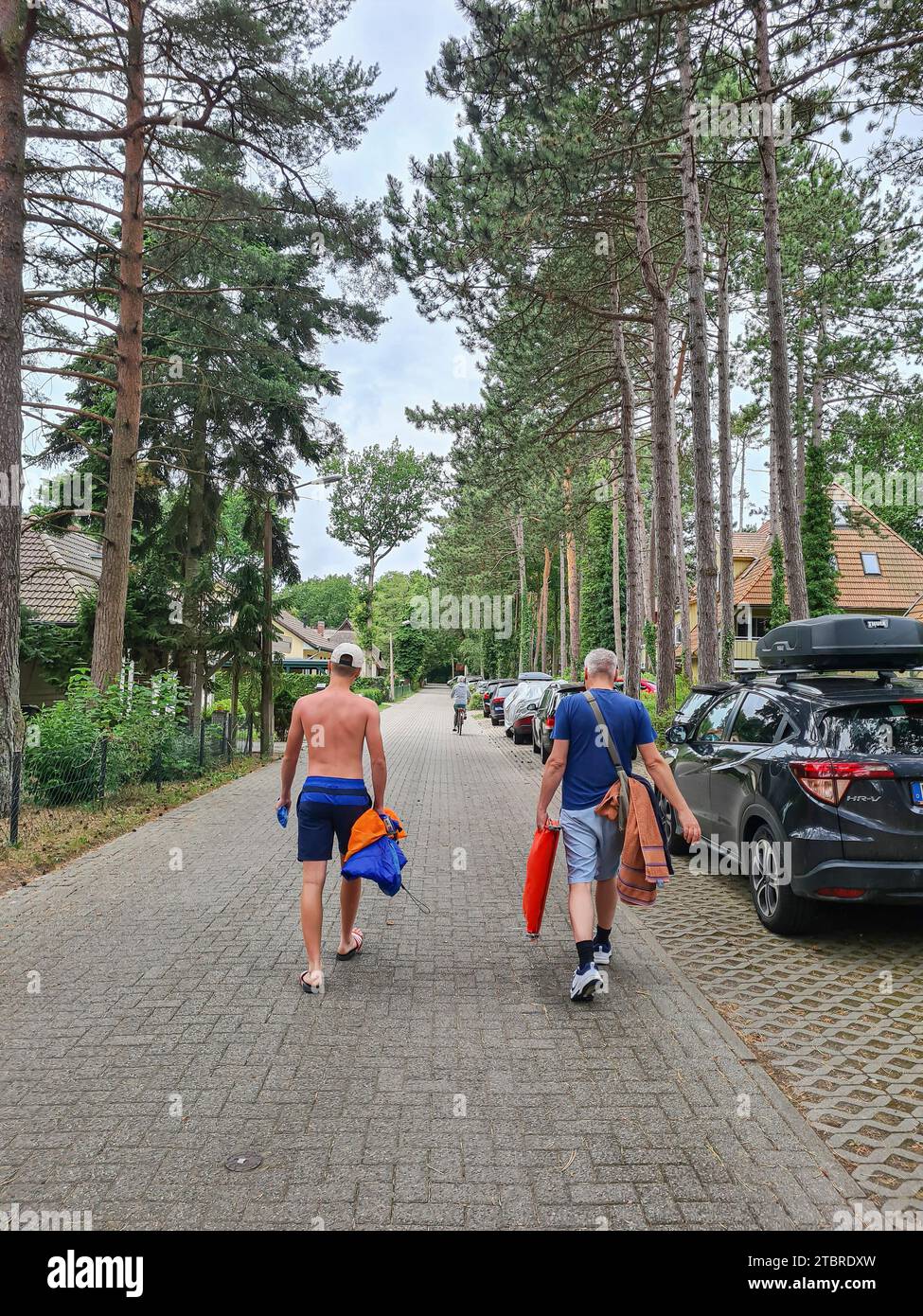 Deutschland, Mecklenburg-Vorpommern, Halbinsel Fischland-Darß-Zingst, Prerow, Vater und Sohn gehen auf der Küsters Allee in Prerow zum Strand Stockfoto