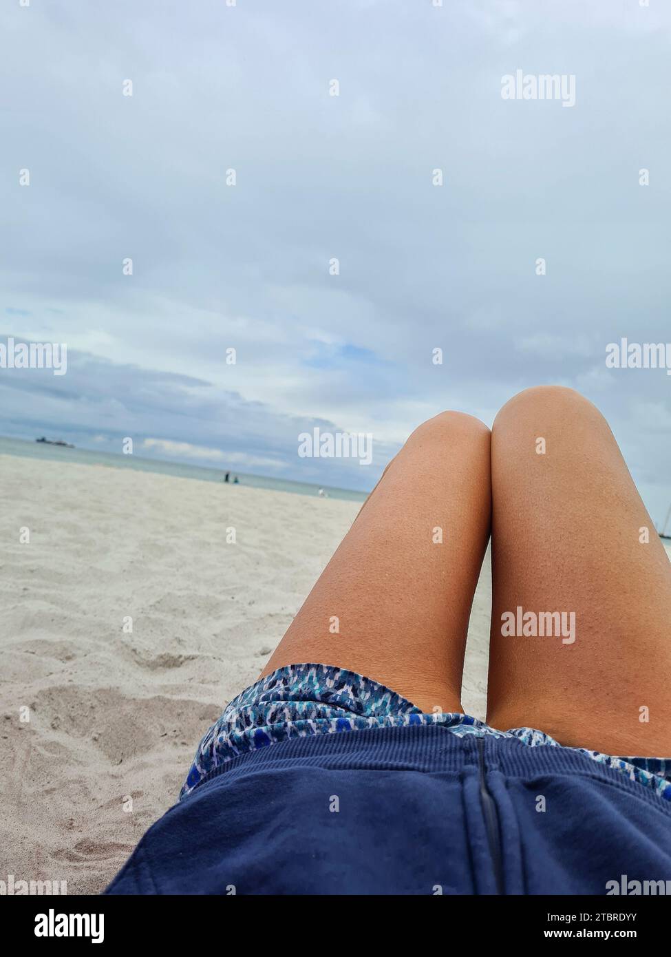 Deutschland, Mecklenburg-Vorpommern, Halbinsel Fischland-Darß-Zingst, Blick über schlanke Frauenbeine am Strand von Prerow Stockfoto