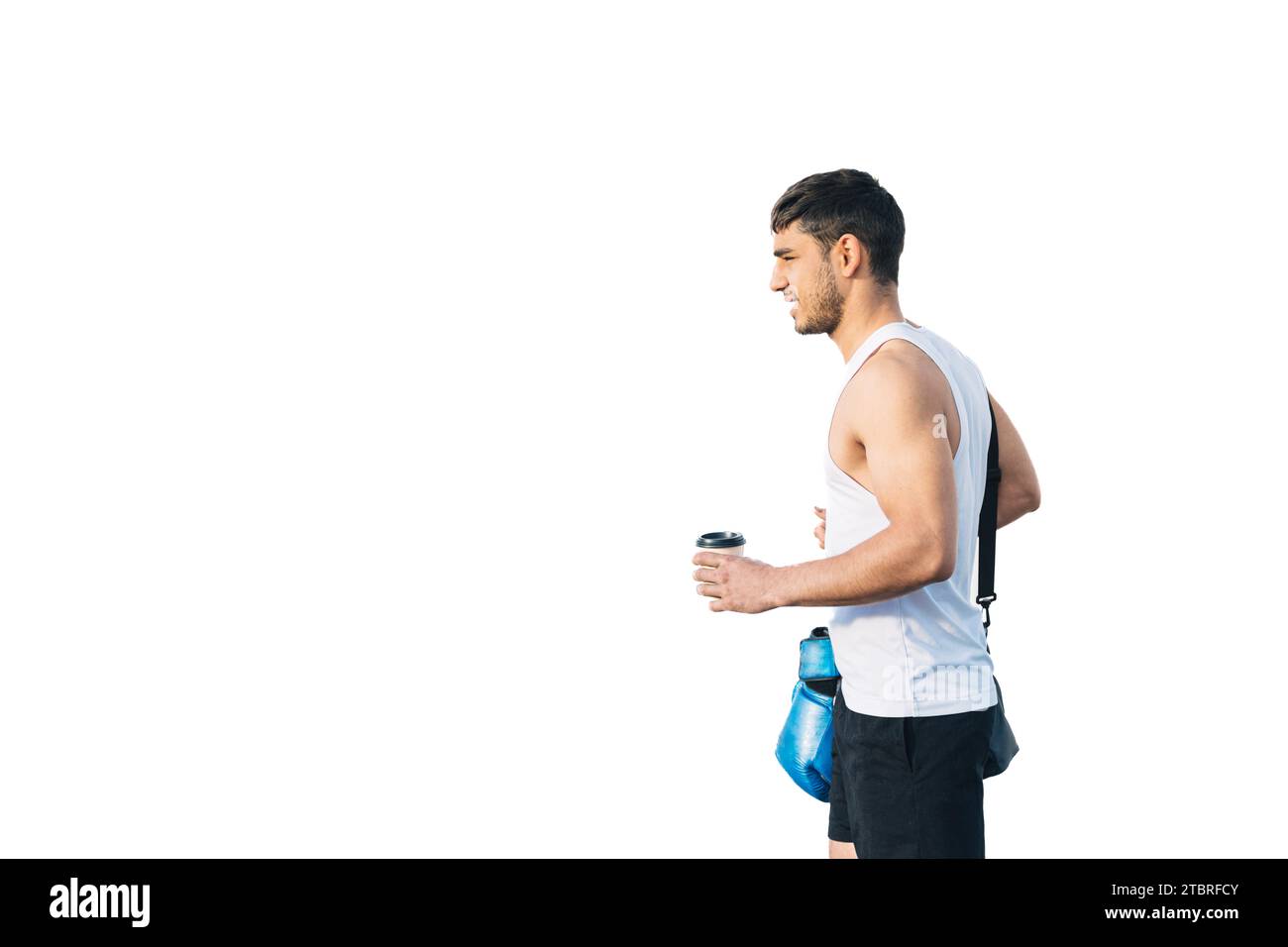 Horizontaler Foto Mann junger Erwachsener gemischtes Rennen, das mit Sportkleidung, Rucksack, blauen Boxhandschuhen und einem Kaffee in der Hand zum Fitnessstudio geht. Auf weiß Stockfoto