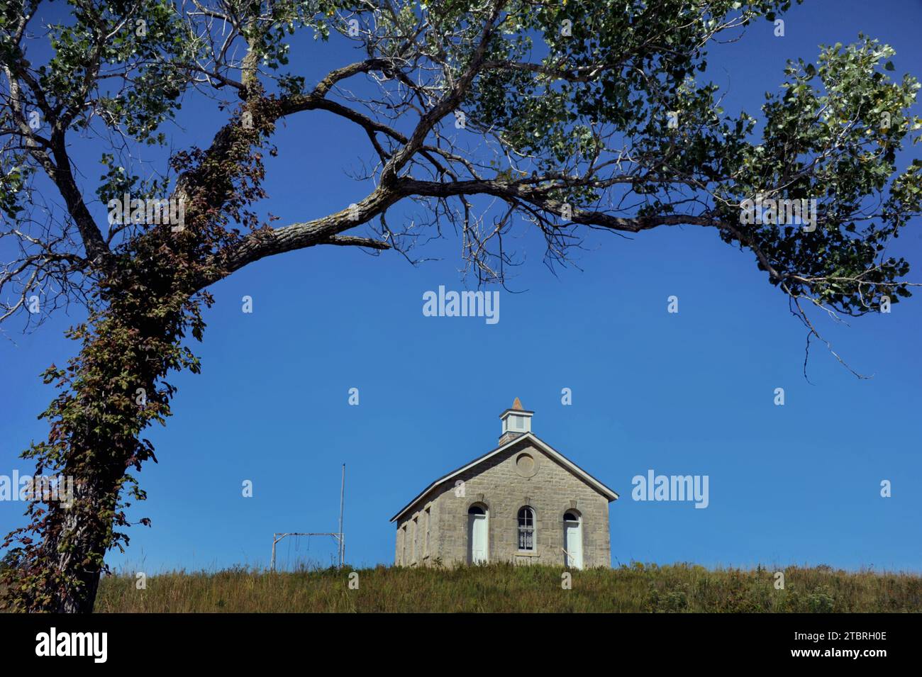 Leer und einsam, ein Zimmer Schulhaus liegt auf einem Hügel auf dem Flint Hills Scenic Byway. Die Lower Fox Creek School ist Teil der Tallgrass Prairie Stockfoto