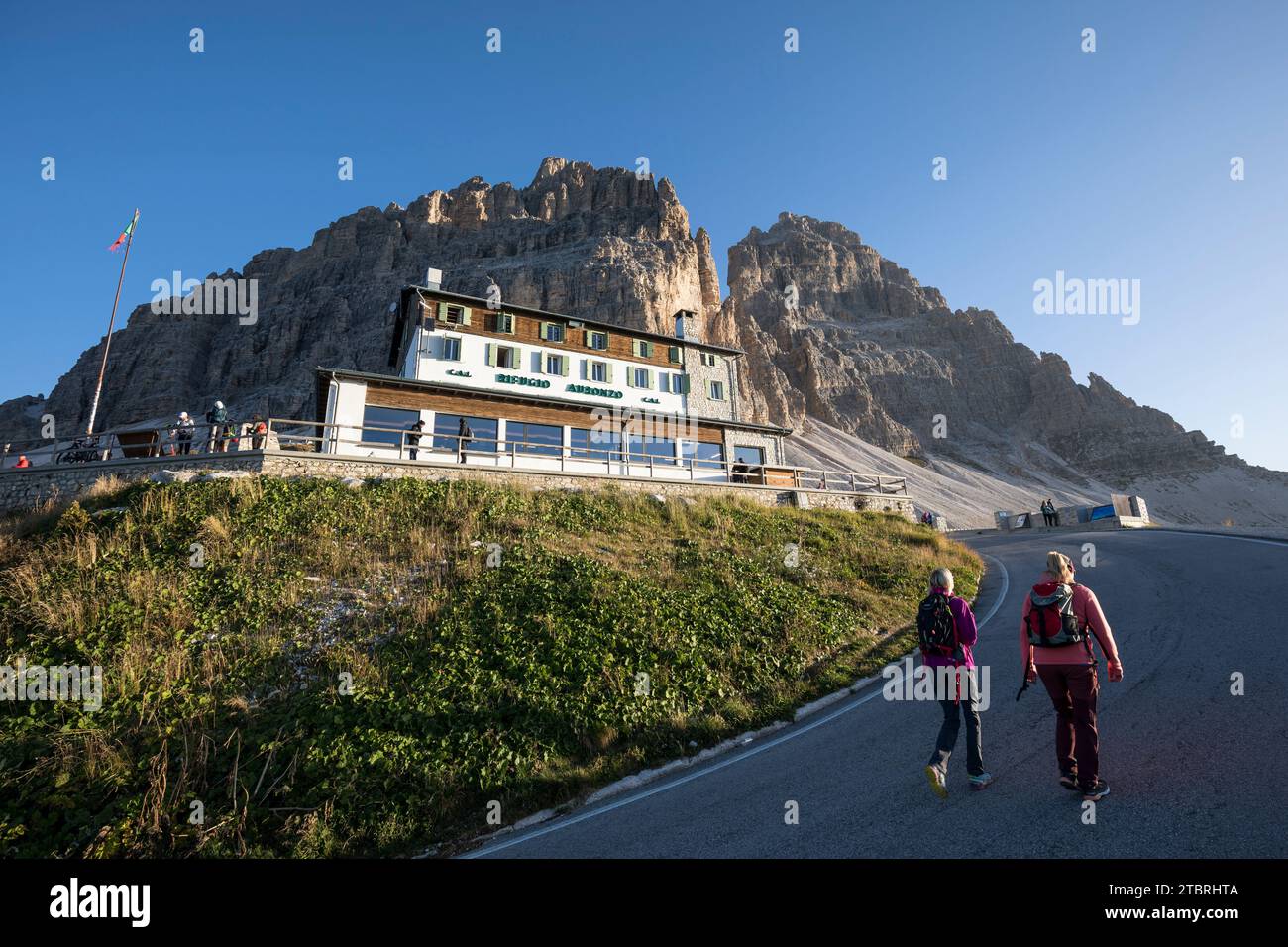 Wanderer vor der Auronzo-Hütte (2320 m), Rifugio Auronzo, am südlichen Fuß der drei Zinnen, mit dem Western Peak und dem Großen Gipfel im Stockfoto