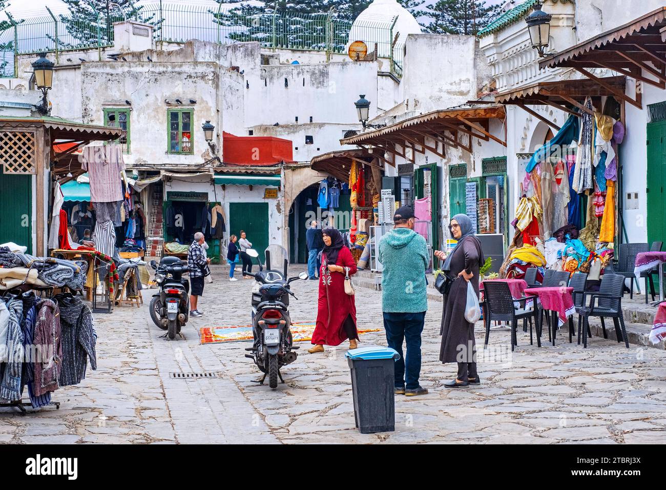 Straßenszene mit Bekleidungsgeschäften und marokkanischen Einheimischen in der Altstadt/Medina der Stadt Tétouan/Tettawen, Marokko Stockfoto