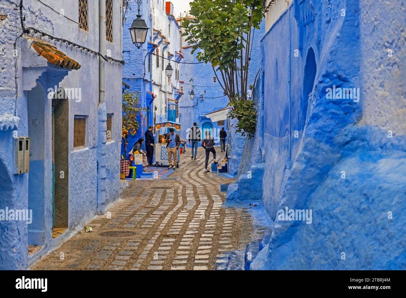 Marokkaner in engen Gassen mit blauen Häusern in Medina / historische Altstadt der Stadt Chefchaouen / Chaouen, Marokko Stockfoto