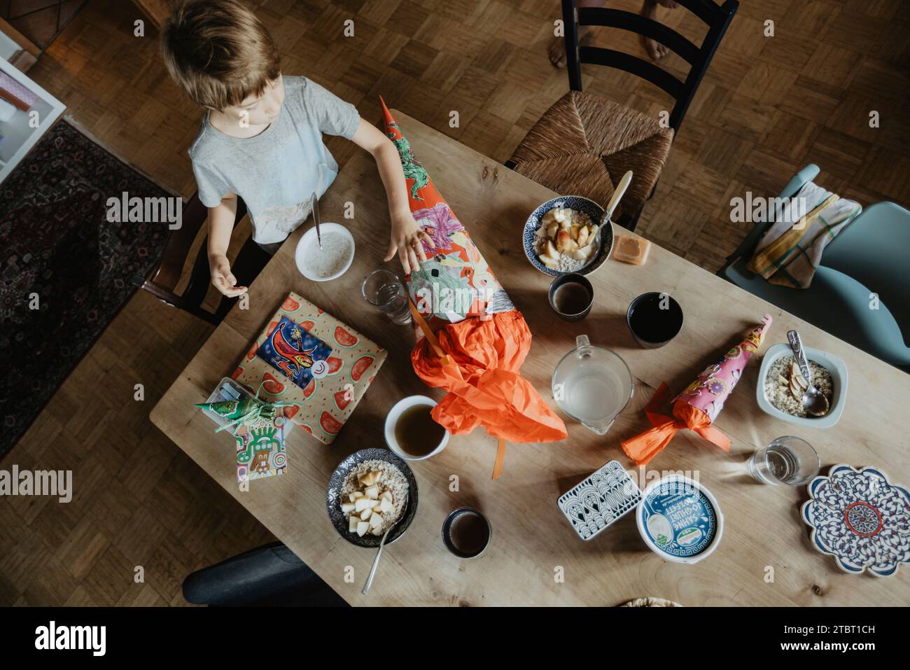 Junge mit Zuckerzapfen am Esstisch Stockfoto