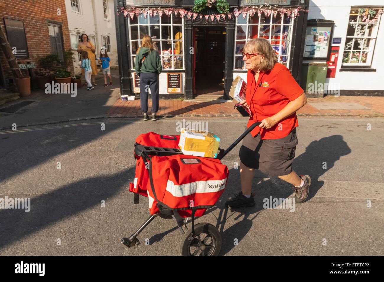 England, East Sussex, Alfriston, Alfriston Village, Royal Mail Postwoman Delivering Mail Stockfoto