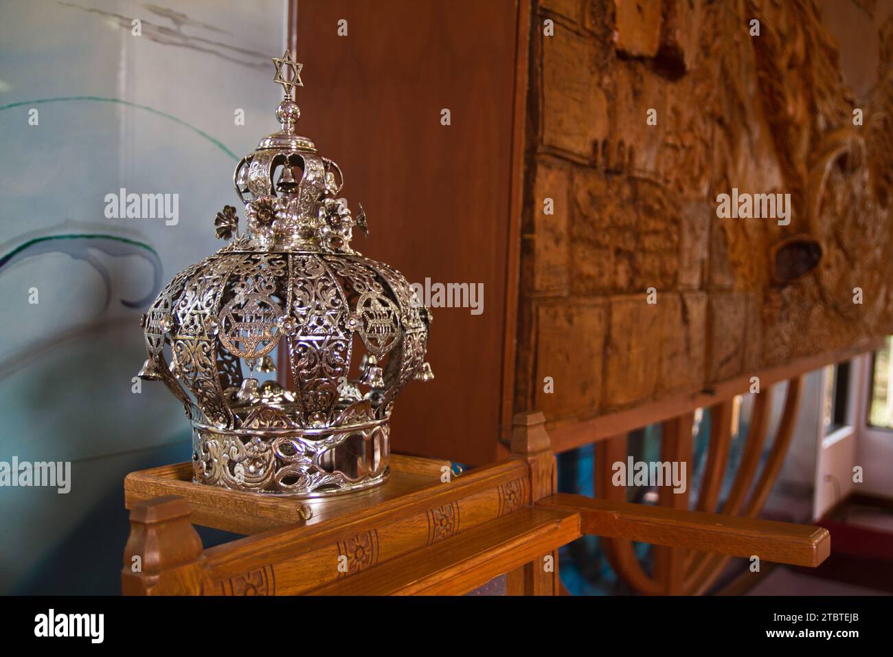 Jüdische zeremonielle Krone auf einem kunstvoll geschnitzten Stand mit texturierter Kunstkulisse Stockfoto