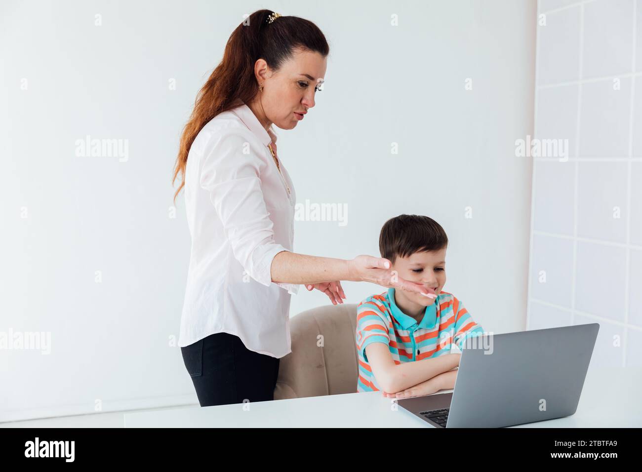 Die Frau bringt dem Jungen bei, online am Computer zu arbeiten Stockfoto