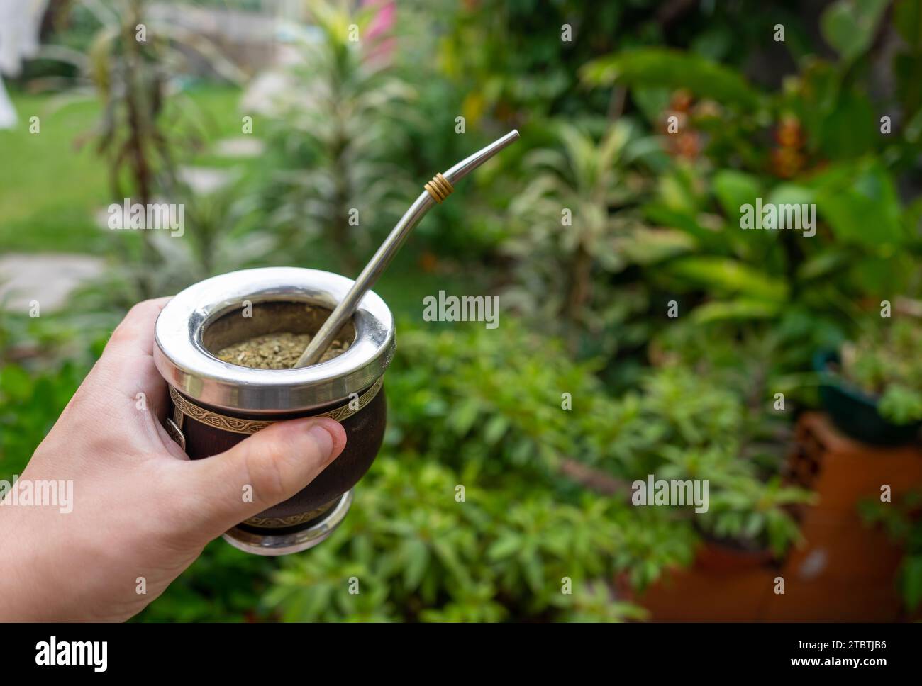 Verknüpfung gefüllt mit Yerba Mate, neben einer roten Thermoskanne Stockfoto