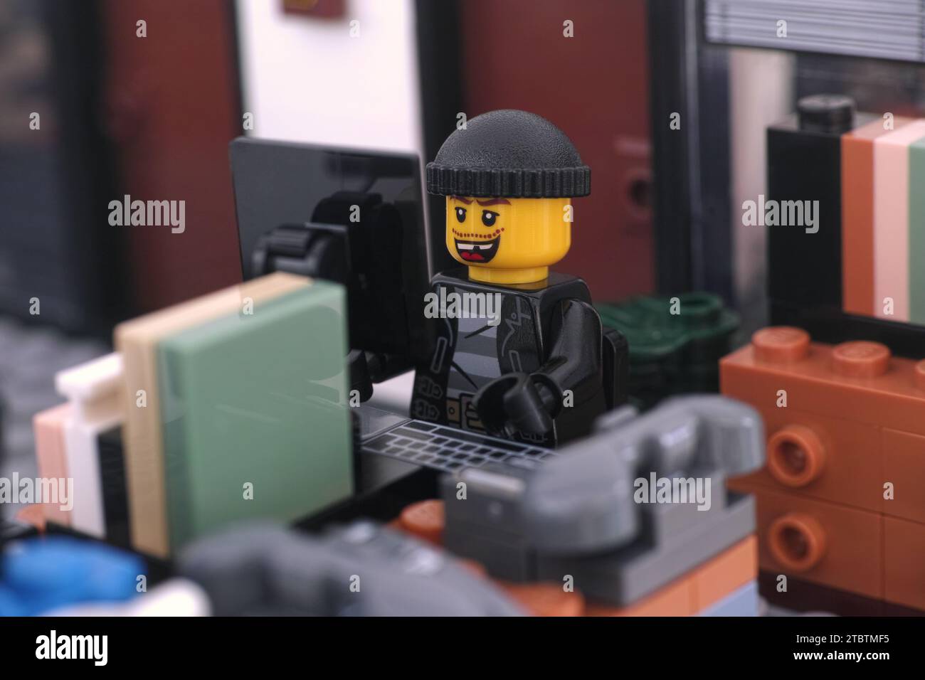 Tambow, Russische Föderation - 8. Dezember 2023 Eine Minifigur eines Lego-Räubers hackt einen Computer in einem Büro. Nahaufnahme. Stockfoto