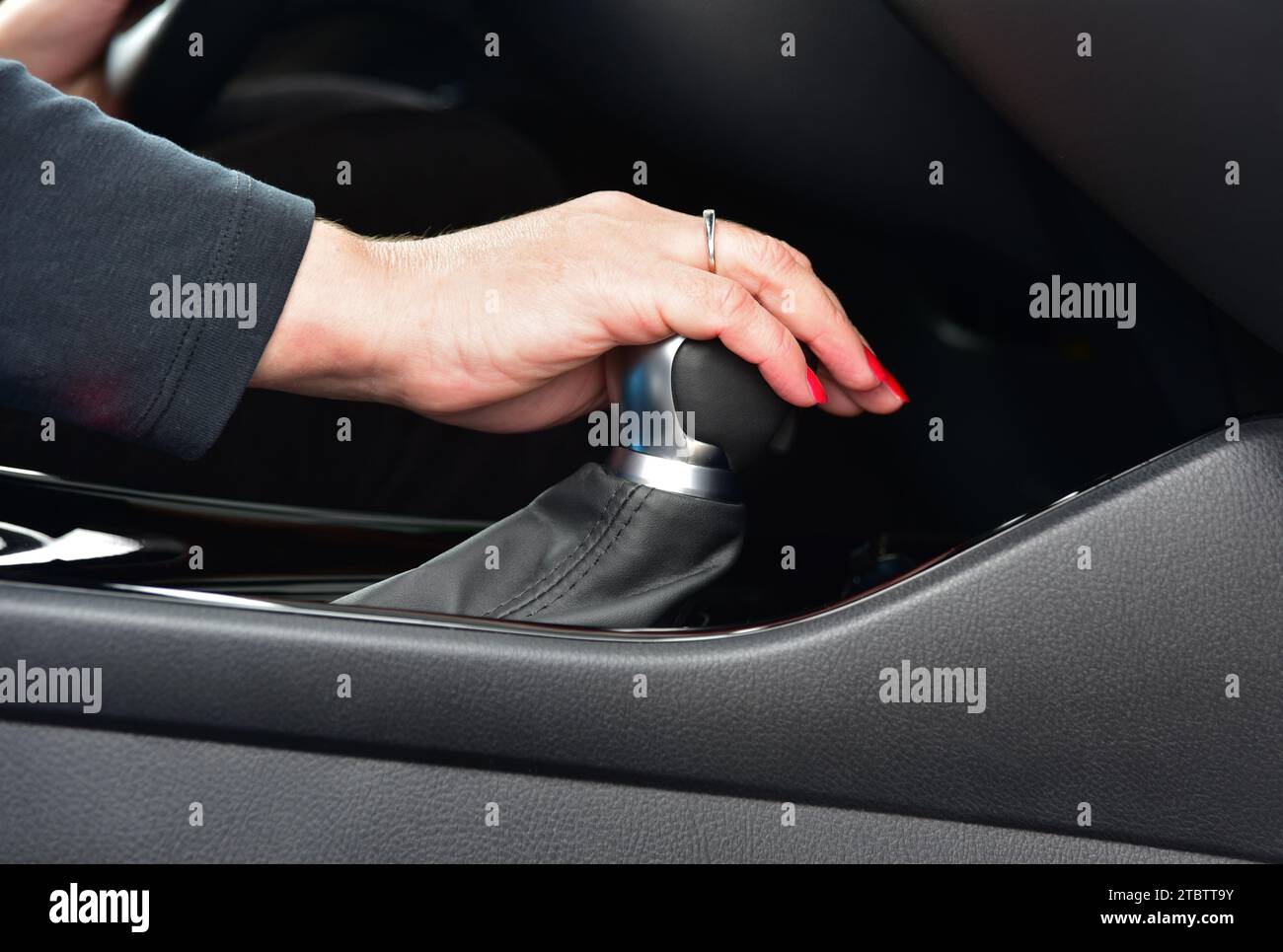 Frau schaltet im Auto die Gänge Stockfoto