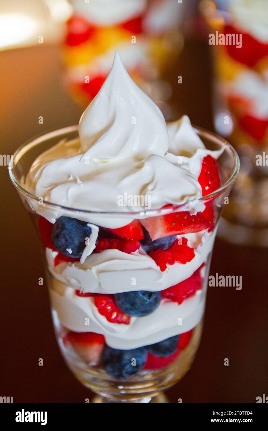 Nahaufnahme des Desserts mit mehrschichtiger Beere und Creme in warmem natürlichem Licht Stockfoto