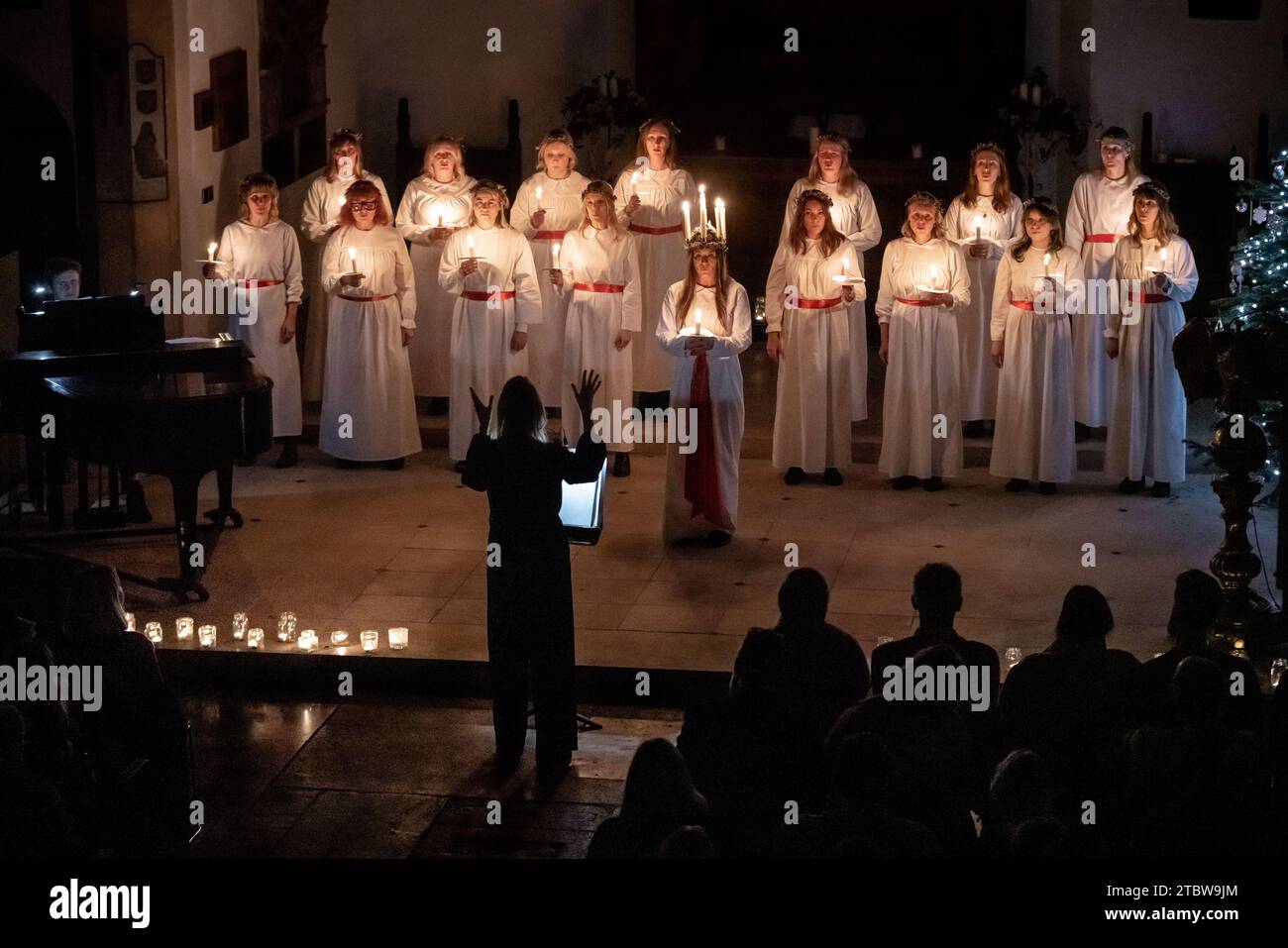 London, Großbritannien. Dezember 2023. Sankta-Lucia-Feiern des schwedischen Chors Norrsång East London in der St. Mary’s Church in Walthamstow. Isabelle Wasmuth Dunnett trägt eine Kerzenkrone, die die hl. Lucy symbolisiert, während sie die Sankta Lucia feiert, basierend auf der Tapferkeit und dem Martyrium eines jungen sizilianischen Mädchens St. Lucy (Lucia von Syrakus 283–304). Guy Corbishley/Alamy Live News Stockfoto