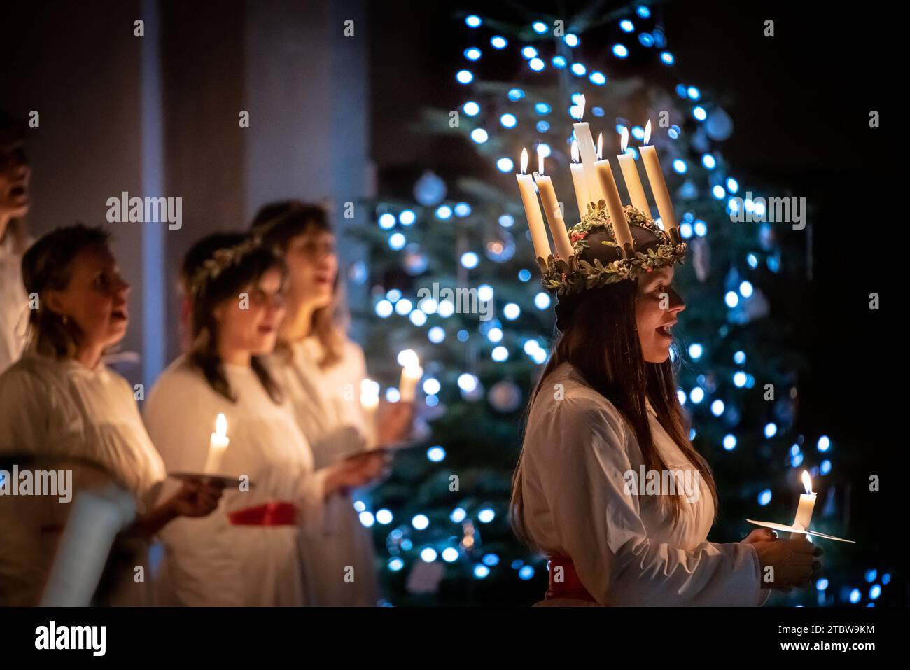 London, Großbritannien. Dezember 2023. Sankta-Lucia-Feiern des schwedischen Chors Norrsång East London in der St. Mary’s Church in Walthamstow. Isabelle Wasmuth Dunnett trägt eine Kerzenkrone, die die hl. Lucy symbolisiert, während sie die Sankta Lucia feiert, basierend auf der Tapferkeit und dem Martyrium eines jungen sizilianischen Mädchens St. Lucy (Lucia von Syrakus 283–304). Guy Corbishley/Alamy Live News Stockfoto