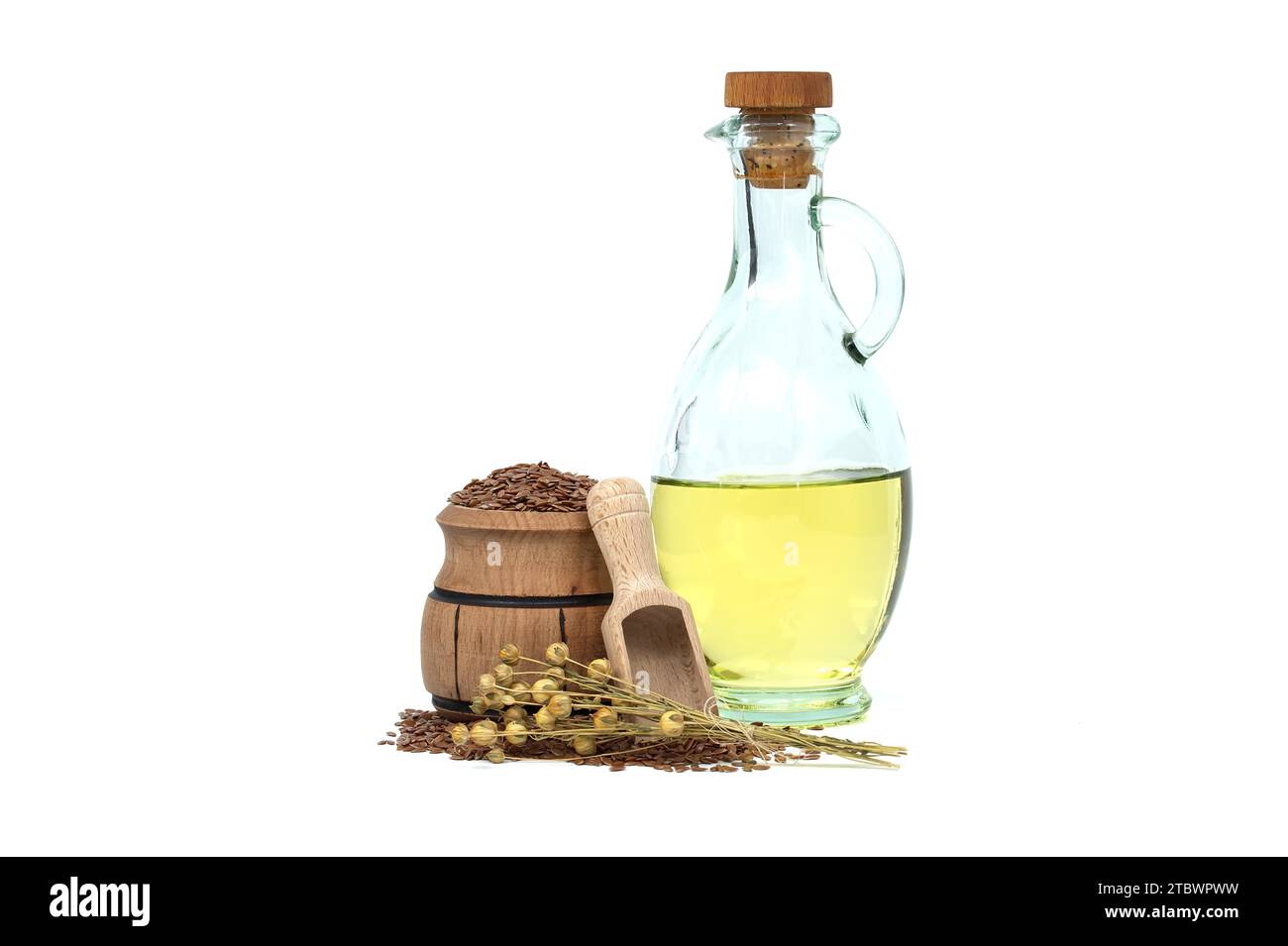 Leinsamenöl in Glasdekanter und Leinsamen in Holzschaufel und Leinpflanzenbündel, isoliert auf weißem Hintergrund. Linum usitatissimum (Gemeiner Flachs) Stockfoto