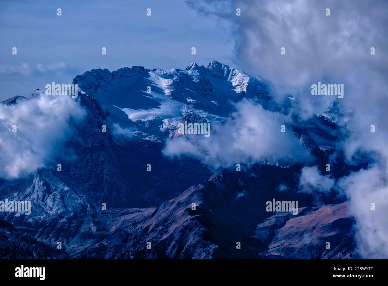 Die Felsformation Marmolada, die im Herbst von Schnee und Wolken bedeckt ist, vom Passo Falzarego aus gesehen. Stockfoto