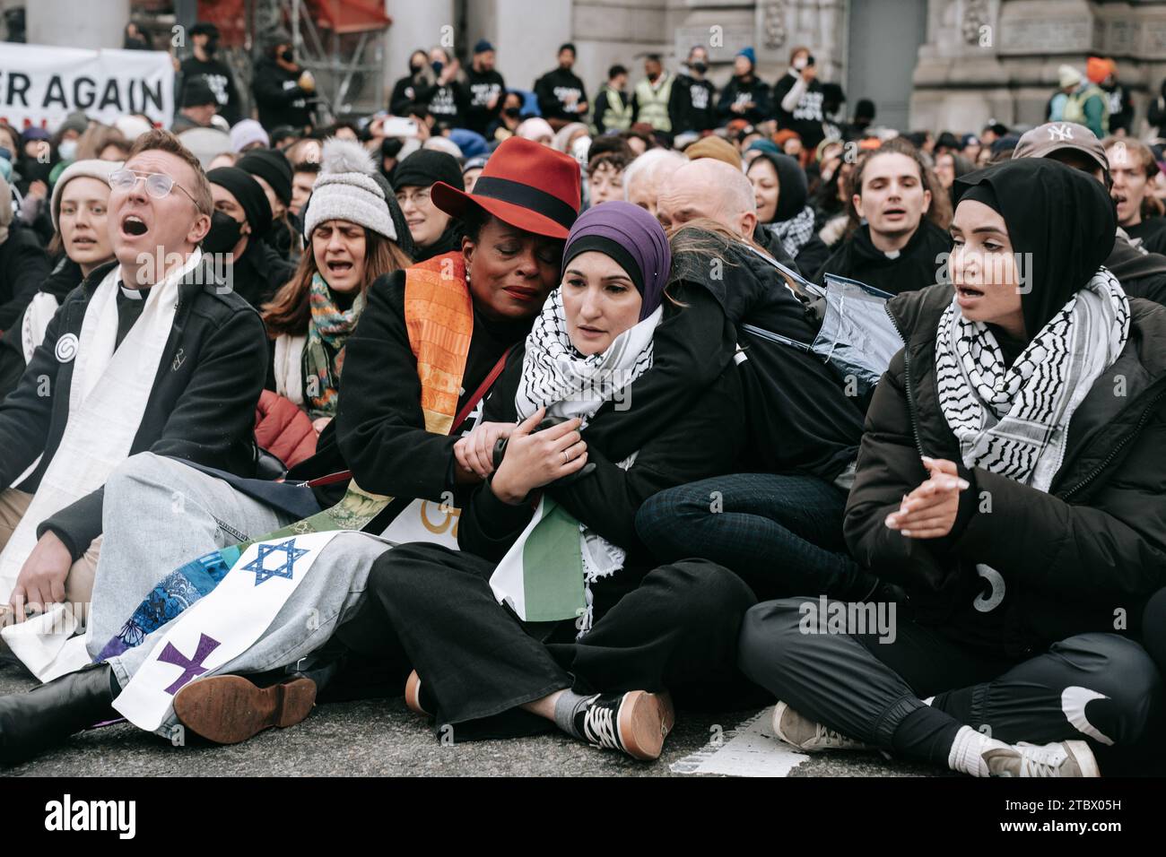 Die politische Aktivistin Linda Sarsour sitzt mit Demonstranten zusammen, während sie die Manhattan Bridge während der Demonstration blockieren. Hunderte Aktivisten der Jewish Voice for Peace, Glaubensführer und Unterstützer schlossen die Manhattan Bridge stundenlang und forderten einen dauerhaften Waffenstillstand im israelisch-Gaza-Krieg. Stockfoto