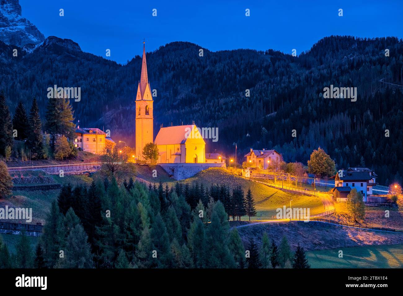 The church Chiesa di San Lorenzo Martire in Selva di Cadore at the foot of Giau Pass, Passo di Giau, illuminated at night in autumn . Stockfoto