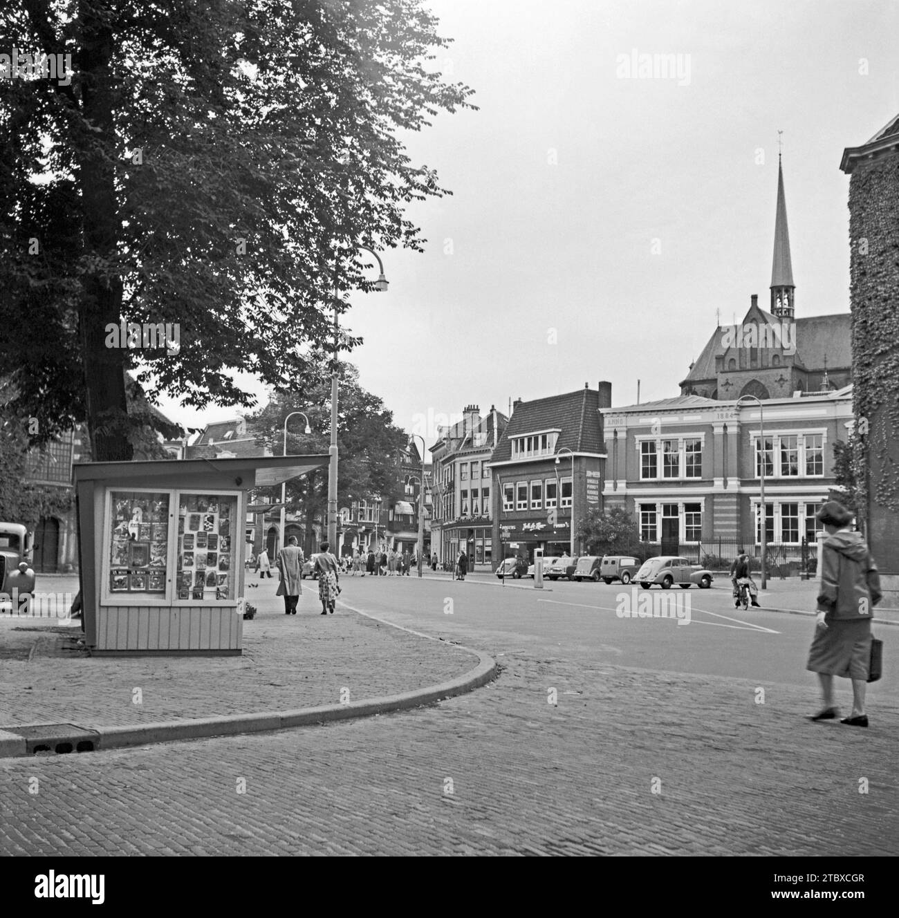 Ein Blick auf Utrecht, Niederlande im Jahr 1955. Dies wurde am Janskerkhof aufgenommen, der vom plaza aus südlich blickte. Die Kirche im Hintergrund ist Sint Willibrordkerk. Utrecht ist die viertgrößte Stadt der Niederlande und die Hauptstadt und bevölkerungsreichste Stadt der Provinz Utrecht. Das antike Stadtzentrum von Utrecht beherbergt viele Gebäude, die bis ins Mittelalter zurückreichen. Es ist seit dem 8. Jahrhundert das religiöse Zentrum der Niederlande. Dieses Bild stammt von einem alten Amateur-Schwarzweiß-negativ eines Besuchers – ein Vintage-Foto aus den 1950er Jahren. Stockfoto