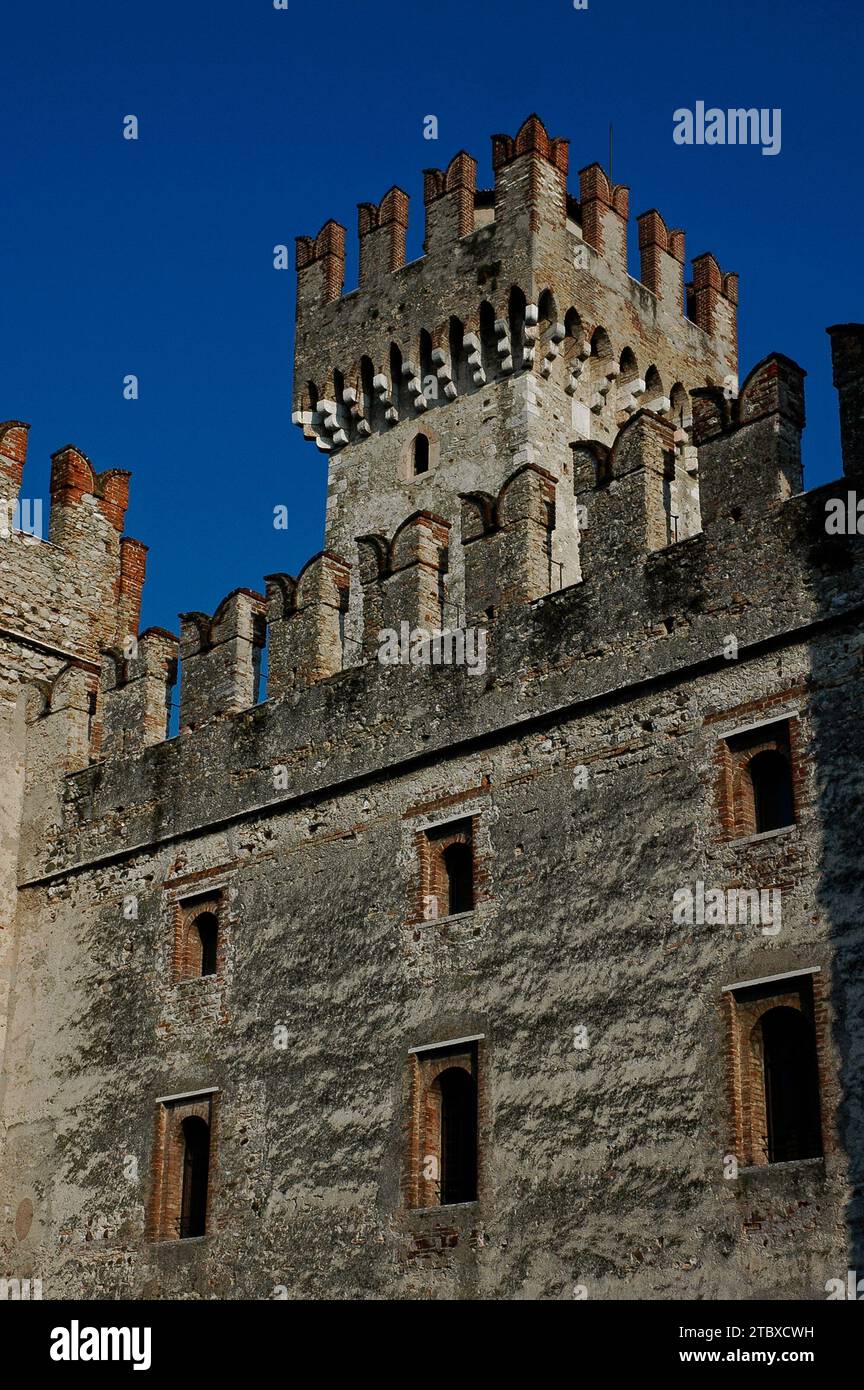 Ein 29 Meter hoher Turm erhebt sich über dem Castello Scaligero oder der Rocca Scaligera in Sirmione am Gardasee in der Lombardei, Italien. Es verfügt über Schwalbenschwanzmauern, die für mittelalterliche Bogenschützen ausgelegt sind, und Machicolations oder „Mordlöcher“, um Angreifer mit heißem Öl oder Felsbrocken abzuwerfen. Die Burg wurde in den 1300er Jahren erbaut und hat ihren Namen von der Familie Della Scala, der Herrscherin in Verona, die das Gebiet zu dieser Zeit dominierte. Es ist eine der am besten erhaltenen Scaliger-Festungen. Stockfoto