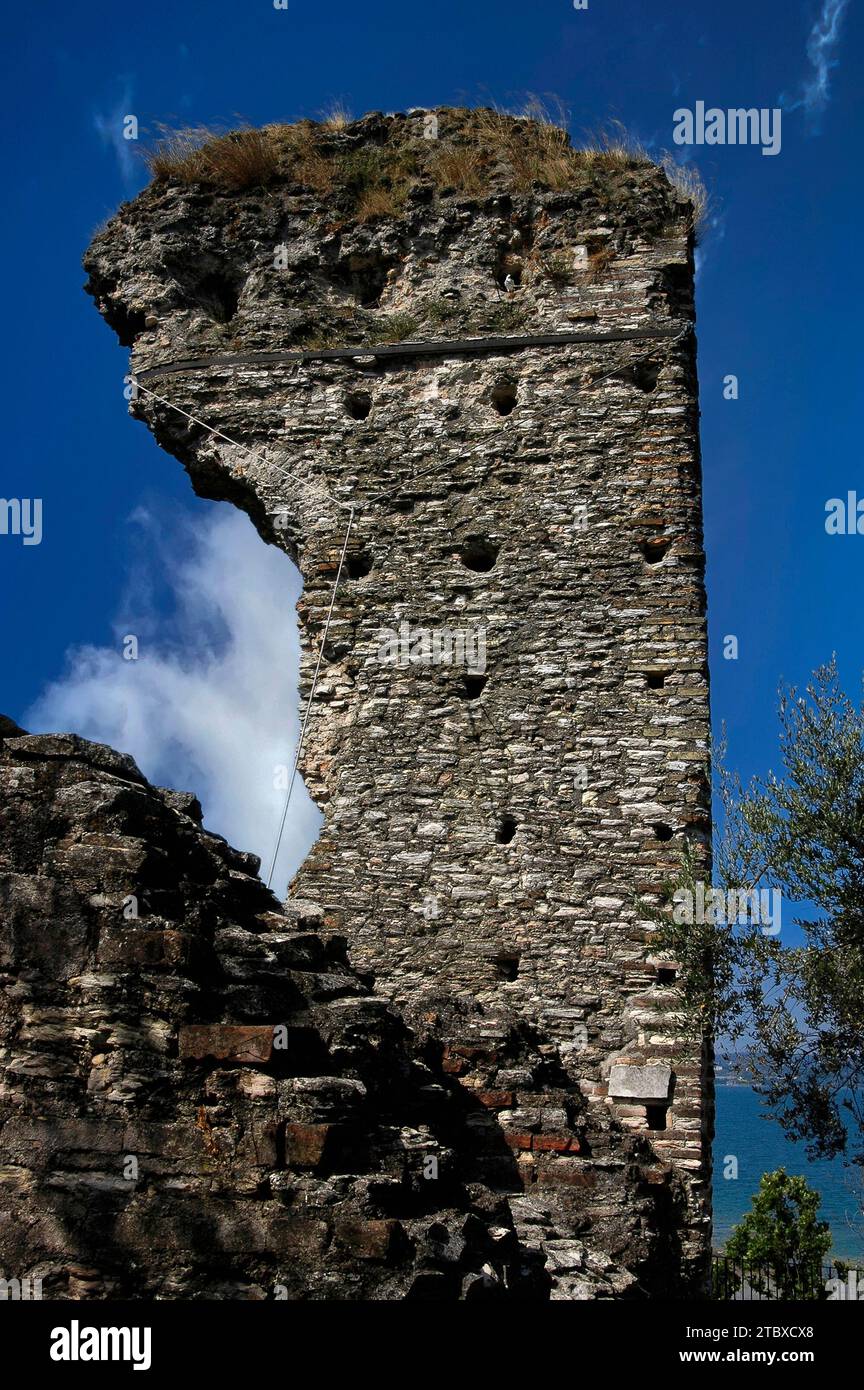 Ein eisernes Band, das an einem Schlepper befestigt ist, hilft, dieses Fragment eines antiken Turms zwischen den Ruinen der Grotte di Catullo, einer römischen Villa in Sirmione auf der Halbinsel Sirmio, einer Landzunge am südlichen Ende des Gardasees in der Lombardei, Italien, zu stabilisieren. Stockfoto