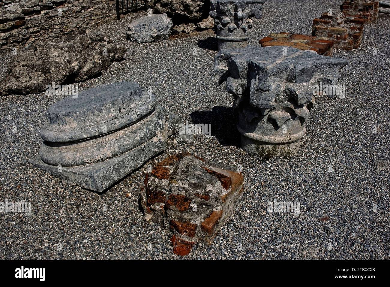 Kapitelle und Skulpturenfragmente inmitten der Ruinen der Grotte di Catullo, einer römischen Villa in Sirmione auf der Halbinsel Sirmio, einer Landzunge am südlichen Ende des Gardasees in der Lombardei, Italien. Stockfoto