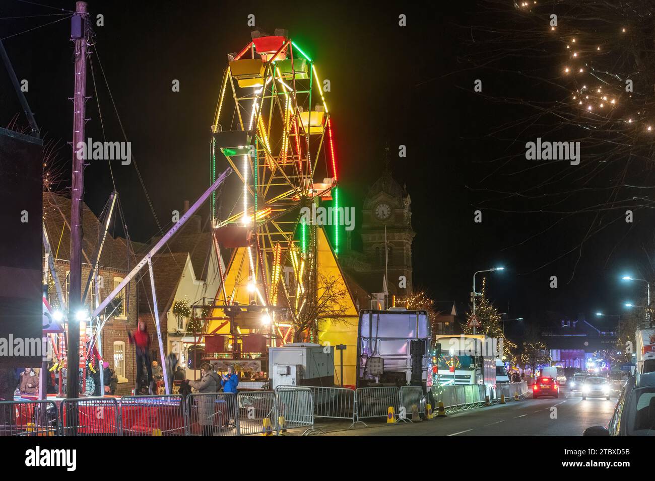 Dezember 2023. Die Hungerford Victorian Extravaganza, eine jährliche Weihnachtsveranstaltung, fand in West Berkshire, England, statt. Der Abend bietet eine Parade mit weihnachtlicher Straßenmesse, festlicher Musik, Speisen und Getränken und Dampfloks. Im Bild: Das große Rad und die Fahrten auf dem Festgelände. Stockfoto