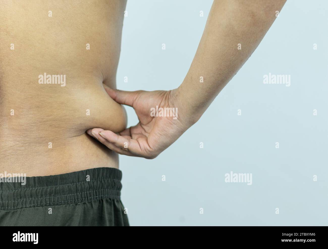 Mann, der Topfbauch oder Bauchfett berührt. Nahaufnahme von Körperteilen Stockfoto