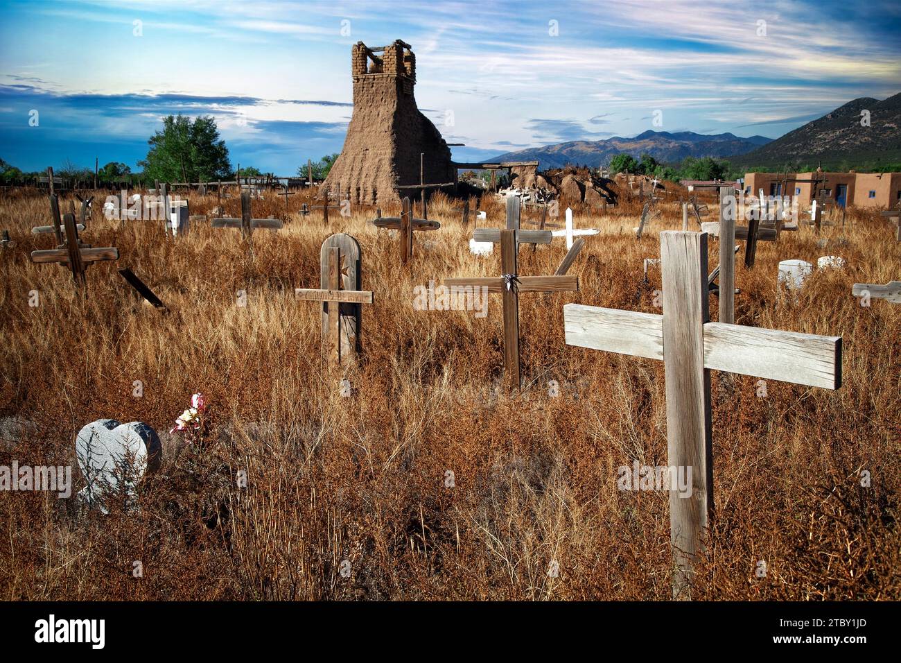 Kreuze von einem Friedhofsfächer über ein Feld, das die Überreste einer alten Kirche in Taos Pueblo, New Mexico, umgibt. Stockfoto