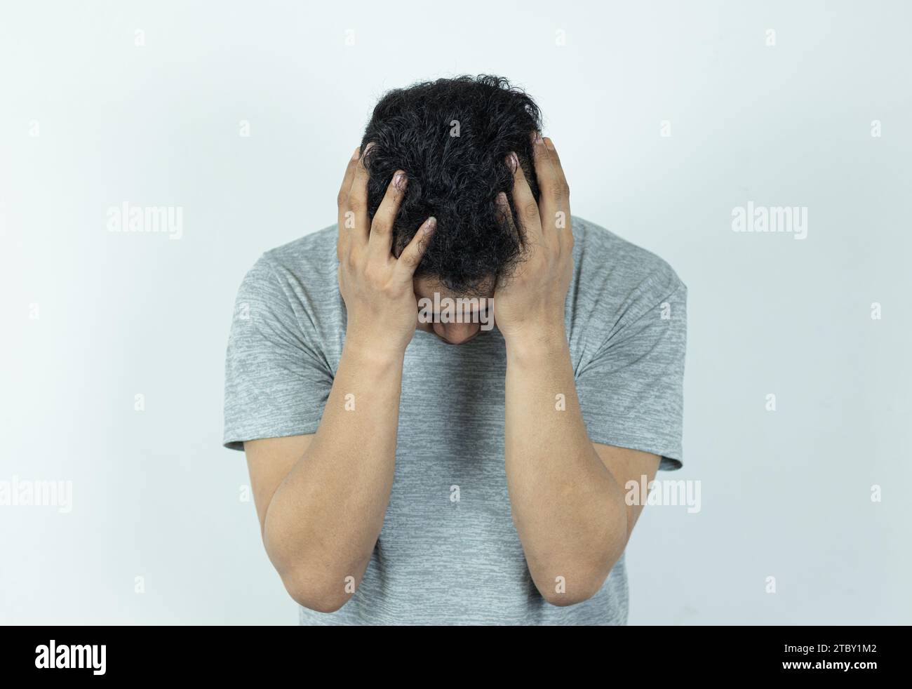 Porträt eines depressiven asiatischen Mannes, der sein Gesicht mit Händen versteckt. Gestresst, hoffnungslos, Frustration, psychische Störungen, Herzbruch und psychische Probleme. Stockfoto