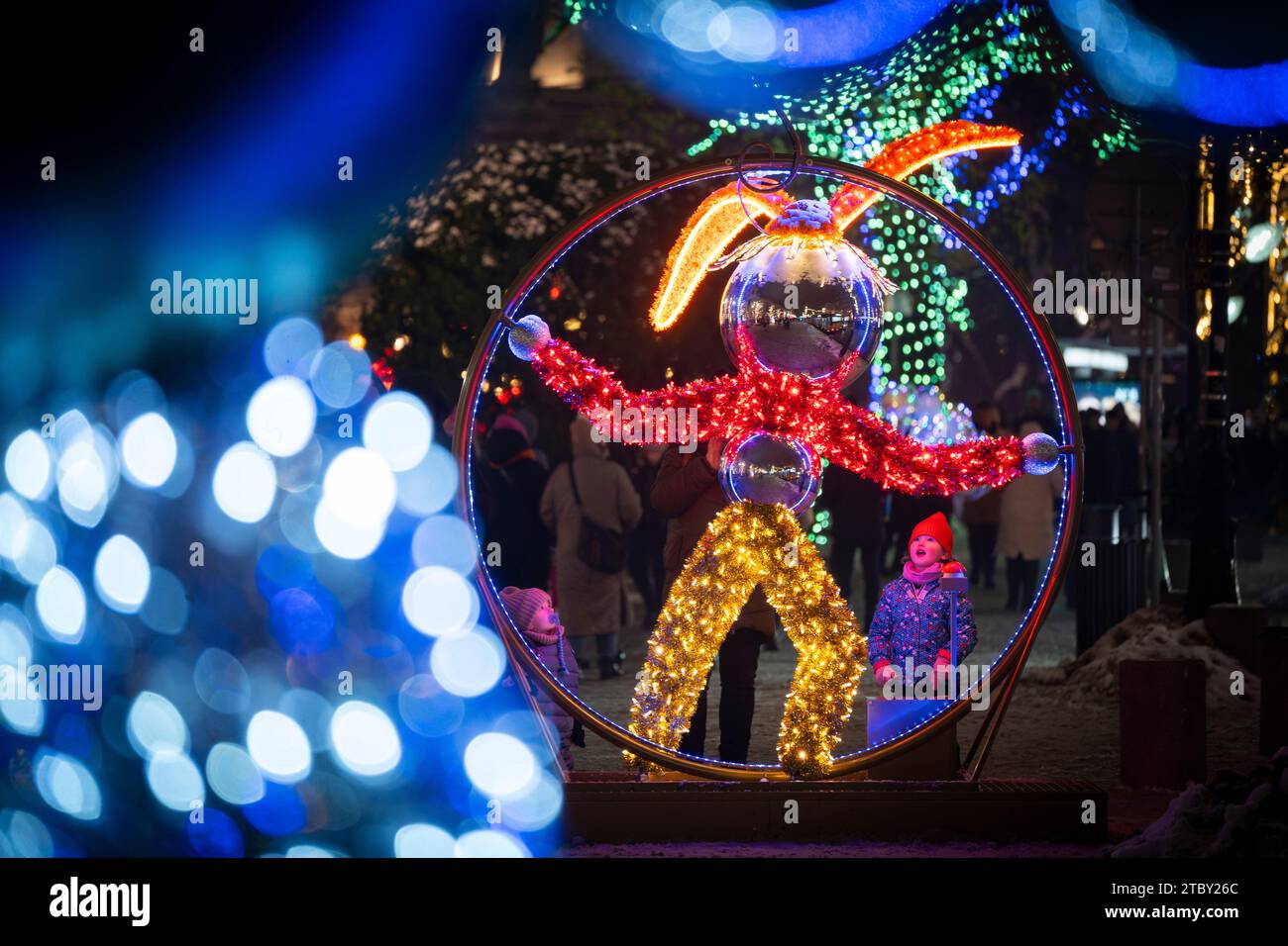 Warschau, Polen. Dezember 2023. Ein kleines Kind blickt am 8. Dezember 2023 zu einer beleuchteten Kaninchenfigur in Warschau, Polen. Das diesjährige Thema für die jährliche Weihnachtsbeleuchtung ist ein Rückblick auf die 50er und 60er Jahre des letzten Jahrhunderts mit verschiedenen Objekten wie klassischen Autos, die mit LED-Leuchten dekoriert sind. (Foto: Jaap Arriens/SIPA USA) Credit: SIPA USA/Alamy Live News Stockfoto