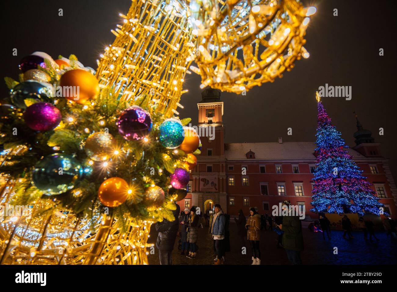 Warschau, Polen. Dezember 2023. Das Königsschloss ist mit dem 27 Meter hohen iilluninierten Weihnachtsbaum in Warschau, Polen, am 08. Dezember 2023 zu sehen. Das diesjährige Thema für die jährliche Weihnachtsbeleuchtung ist ein Rückblick auf die 50er und 60er Jahre des letzten Jahrhunderts mit verschiedenen Objekten wie klassischen Autos, die mit LED-Leuchten dekoriert sind. (Foto: Jaap Arriens/SIPA USA) Credit: SIPA USA/Alamy Live News Stockfoto