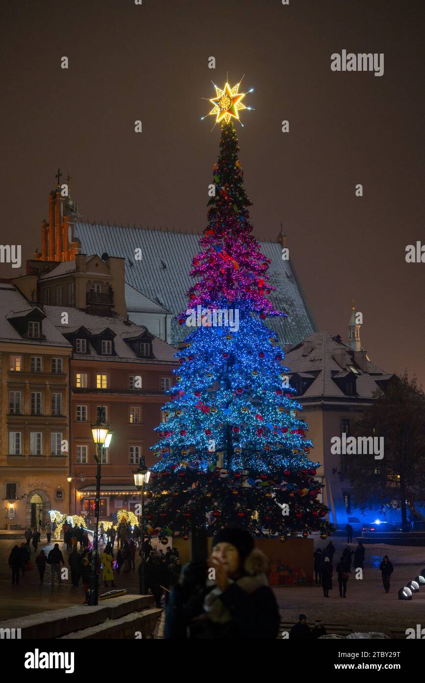 Warschau, Polen. Dezember 2023. Eine Frau macht am 08. Dezember 2023 ein Selfie vor dem 27 Meter hohen, beleuchteten Weihnachtsbaum in der Altstadt von Warschau, Polen. Das diesjährige Thema für die jährliche Weihnachtsbeleuchtung ist ein Rückblick auf die 50er und 60er Jahre des letzten Jahrhunderts mit verschiedenen Objekten wie klassischen Autos, die mit LED-Leuchten dekoriert sind. (Foto: Jaap Arriens/SIPA USA) Credit: SIPA USA/Alamy Live News Stockfoto