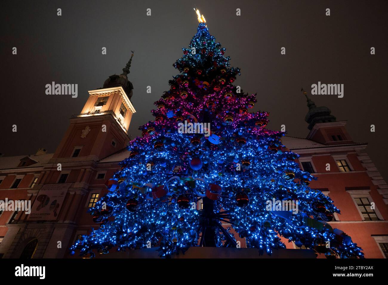 Warschau, Polen. Dezember 2023. Das Königsschloss ist mit dem 27 Meter hohen iilluninierten Weihnachtsbaum in Warschau, Polen, am 08. Dezember 2023 zu sehen. Das diesjährige Thema für die jährliche Weihnachtsbeleuchtung ist ein Rückblick auf die 50er und 60er Jahre des letzten Jahrhunderts mit verschiedenen Objekten wie klassischen Autos, die mit LED-Leuchten dekoriert sind. (Foto: Jaap Arriens/SIPA USA) Credit: SIPA USA/Alamy Live News Stockfoto