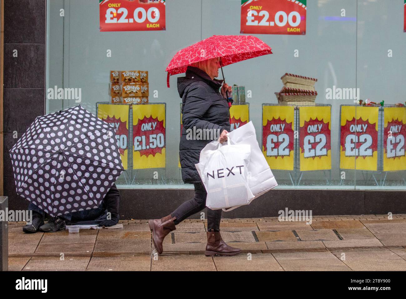 Preston, Großbritannien. Dezember 2023. Weihnachtsläden, Shopper, Einkaufen an einem nassen Tag in der Fishergate High Street. Kredit ; MediaWorldImages/AlamyLiveNews Stockfoto