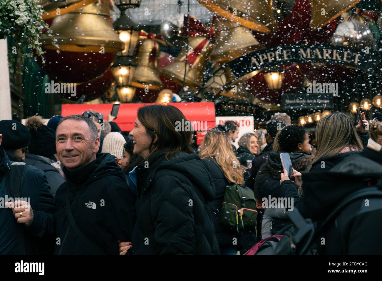 Leute, die den falschen Schneefall in London genießen, Covent Garden Stockfoto