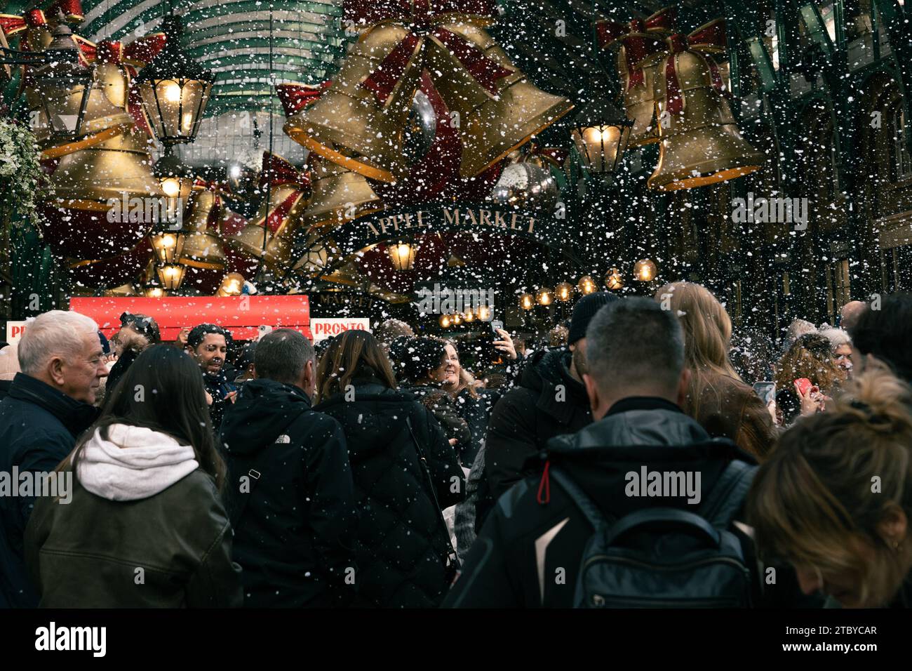 Leute, die den falschen Schneefall in London genießen, Covent Garden Stockfoto