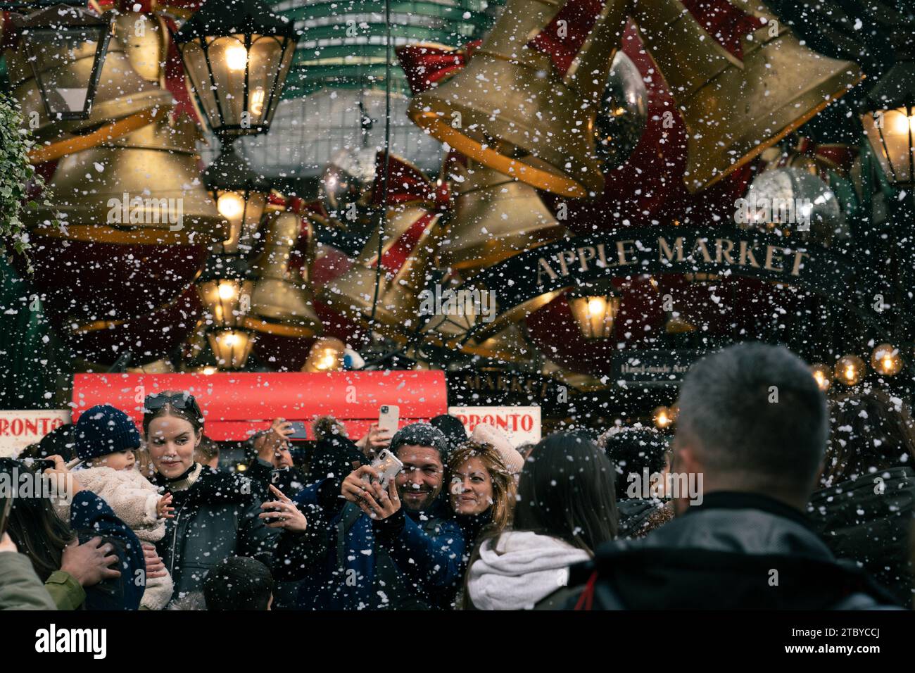 Leute, die den falschen Schneefall in London genießen, Covent Garden Stockfoto