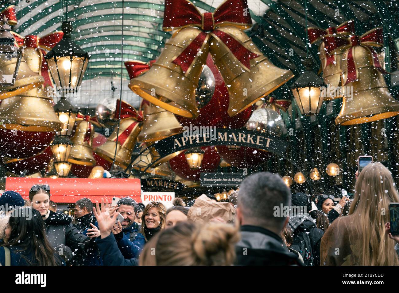 Leute, die den falschen Schneefall in London genießen, Covent Garden Stockfoto